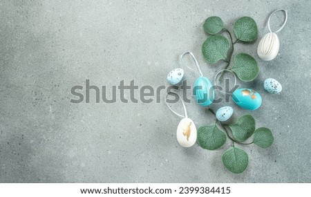 Easter frame of eggs and green leaves on gray background. Happy Easter holiday concept.
