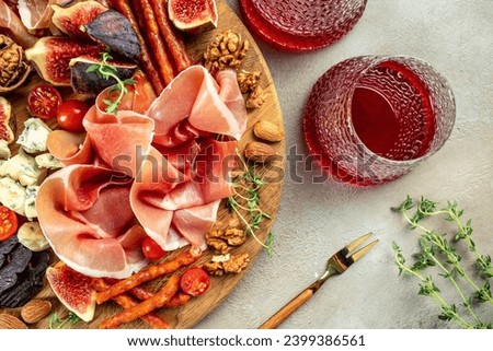 Appetizer from dry cured ham, prosciutto slices with figs and cheese. Dinner or aperitivo party concept. place for text, top view. Royalty-Free Stock Photo #2399386561