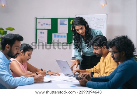 Team of co-workers busy working at office during discussion or business training - concept of communication, startup coordination and woman leadership. Royalty-Free Stock Photo #2399394643