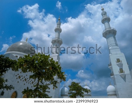 You can see the mosque dome and mosque tower high in the bright blue sky and white clouds of the Syech Zayed mosque building in Solo, Central Java, Indonesia  Royalty-Free Stock Photo #2399396923