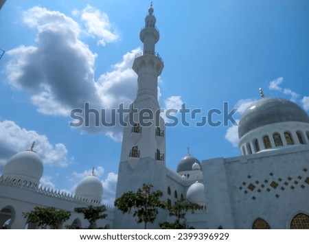 You can see the mosque dome and mosque tower high in the bright blue sky and white clouds of the Syech Zayed mosque building in Solo, Central Java, Indonesia  Royalty-Free Stock Photo #2399396929
