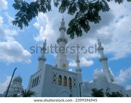 You can see the mosque dome and mosque tower high in the bright blue sky and white clouds of the Syech Zayed mosque building in Solo, Central Java, Indonesia  Royalty-Free Stock Photo #2399396945