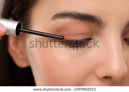 Woman applying serum onto her eyelashes, closeup. Cosmetic product Royalty-Free Stock Photo #2399402013