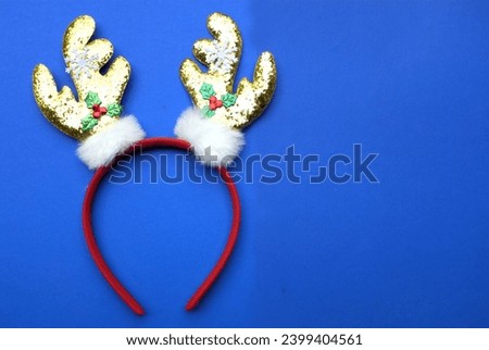 cute Headband Christmas, Christmas deer horns isolate on a blue backdrop. concept of joyful Christmas party,New year is coming soon, festive season decoration with Christmas elements