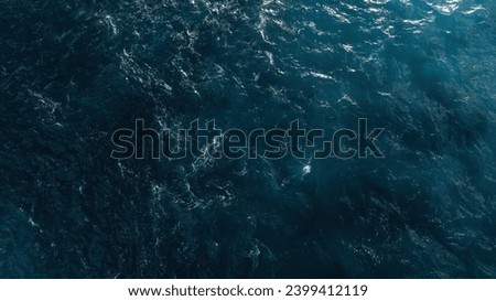 Aerial view of the dark blue ocean with textured water patterns and light reflections. Drobe Shot