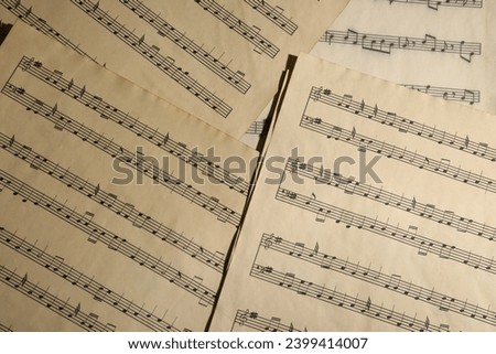 Many old note sheets as background, top view