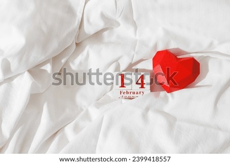 14 february lifestyle background, holiday date on calendar in bed, red paper 3d heart and wood calendar on white cotton sheet. Valentine's Day concept. Festive romance dating, minimal aesthetic trend Royalty-Free Stock Photo #2399418557