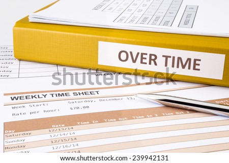Overtime words on document binder place on blank weekly time sheets Royalty-Free Stock Photo #239942131