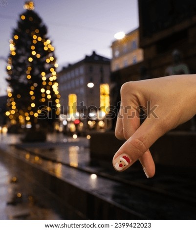 Santa claus cartoon on nail of thumb acting miniheart shape with Christmas tree background Norway