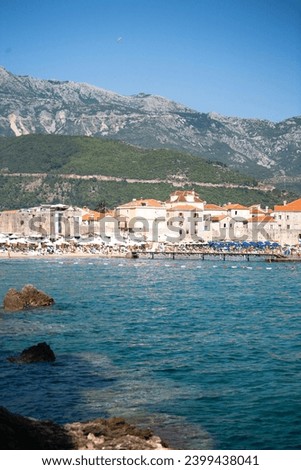 Seascape with the old town and city beach of Budva against the backdrop of mountains from the Adriatic Sea, Montenegro, for publication, poster, calendar, banner, cover, post, web. High quality photo