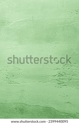 Green textured concrete background with light base darker in the recesses. Abstract texture for graphic design or wallpaper, top view