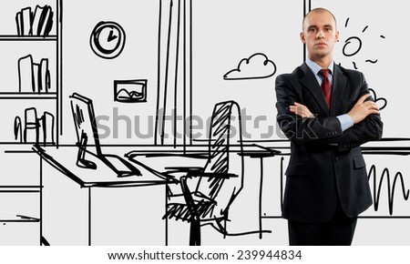 Young confident businessman standing in drawn office