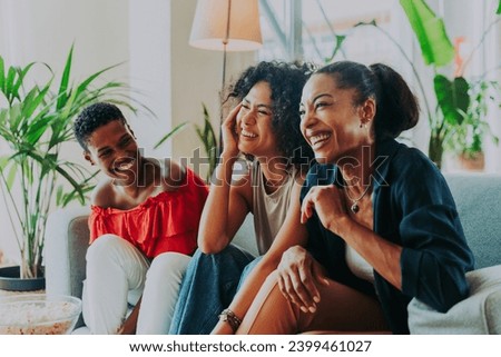Happy beautiful hispanic south american and black women meeting indoors and having fun - Black adult females best friends spending time together, concepts about domestic life, leisure and friendship Royalty-Free Stock Photo #2399461027