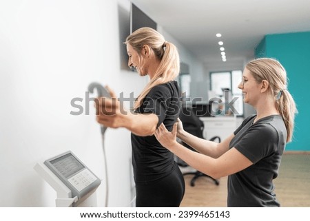 trainer assisting a client on a body composition medical scale for a Inbody test in a gym, both smiling. Royalty-Free Stock Photo #2399465143