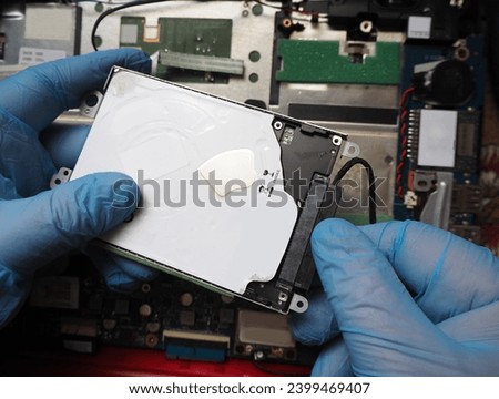 Technician installing hard disk to computer. Removing or plugging in disk cable. Data recovery concept background.