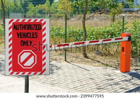 Sign with text Authorized Vehicles Only near boom barrier outdoors