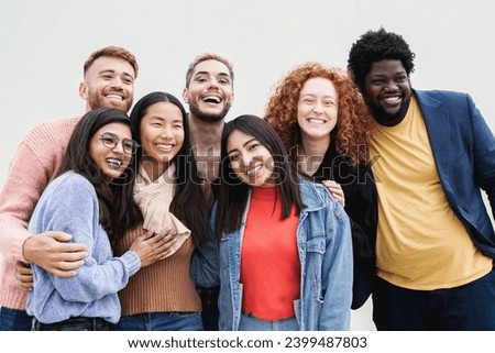 Diverse group of friends having fun smiling at camera outdoor. Young people celebrate together outside Royalty-Free Stock Photo #2399487803
