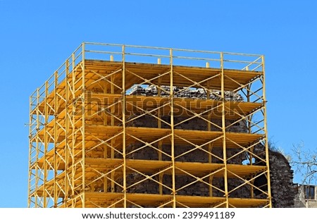Bright yellow scaffolding built around the restored site of an ancient fortress tower in Istanbul