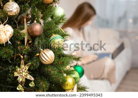 Christmas shopping online, sales and discounts promotions during winter holidays, online shopping at home. Female hands on the laptop with gifts and blurred bokeh lights. High quality photo