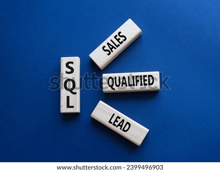 SQL - Sales Qualified Lead. Wooden cubes with words SQL. Beautiful deep blue background. Business and SQL concept. Copy space.