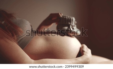 happy pregnant woman. booties baby shoes on the belly of lifestyle a pregnant woman. pregnancy health procreation concept. close-up belly of a pregnant woman. woman waiting for a newborn baby Royalty-Free Stock Photo #2399499309