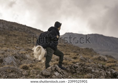 Young woman with backpack on mountain hike, sitting, resting, standing, making a fire