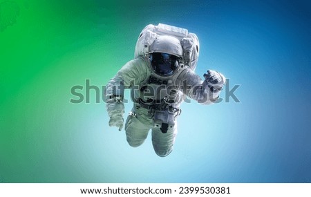 Spaceman floating in space. Astronaut on bright blue and green background. Man in space suit fly. Sci-fi wallpaper. Graphic design space concept. Elements of this image furnished by NASA