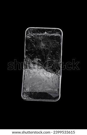 Mobile smartphone with broken screen on black background.