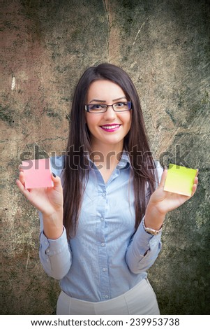 Young woman holding two post it in her hands
