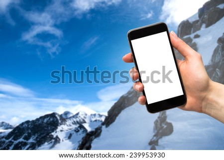 smartphone in the hands of women and the mountains in winter