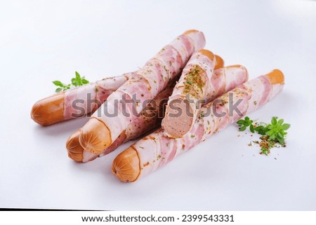 Traditional raw Bernese bratwurst wrapped with cheese and ham offered as close-up on white background with text free space 