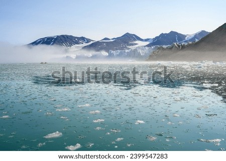 Adventure seeking people kayaking in the freezing waters of the arctic ocean at the base of the Monacobreen Glacier in Liefde Fjord, Svalbard, travel in the arctic summer
 Royalty-Free Stock Photo #2399547283