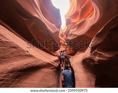 People in water shaped smooth sandstone walls to unusual curves and adges in antelope national park in arizona, america, usa Royalty-Free Stock Photo #2399550975