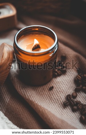 Burning candle and coffee beans, cozy photo.