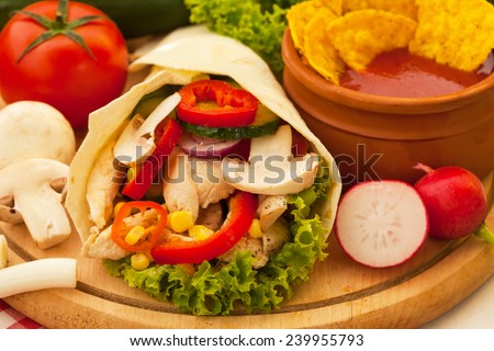Fried spicy chicken and vegetables wrapped in a tortilla roll 