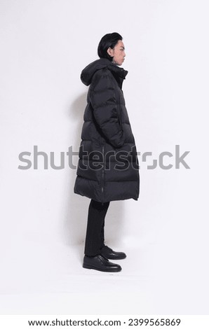 Full body portrait of handsome male  wearing warm coat  with backpack posing on white background