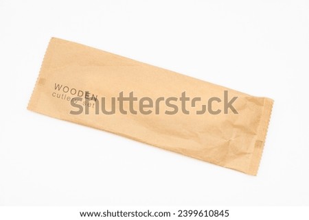 Paper Packaging of Wooden Cutlery in  Isolated, Eco Tableware, Disposable Cutlery, Recycle. Eco food packaging concept, zero waste paper, sustainability. Royalty-Free Stock Photo #2399610845