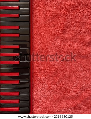 Black red Melodica top view on red background and space for text