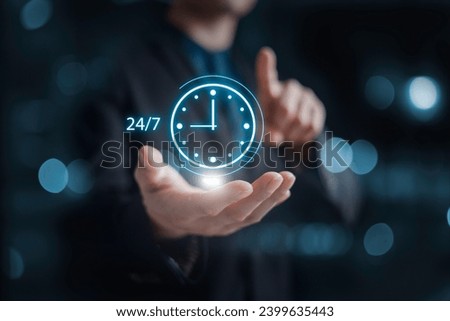 nonstop service concept. businessman hand holding virtual 24-7 with clock on hand for smart phone nonstop and full-time available contact of service concept. customer service. Royalty-Free Stock Photo #2399635443