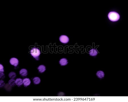 Blurred purple street car lights bokeh at night for festive travel background.