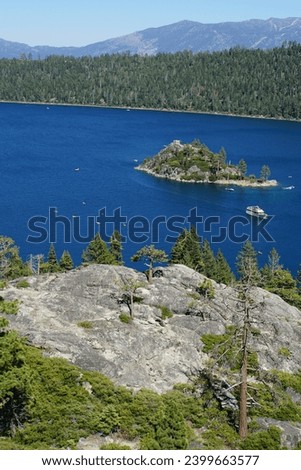 iew of the tea house on Fannette Island at Emerald Bay in Lake Tahoe, California, from the viewpoint at Vikingsholm parking lot on a sunny day