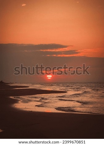 As the day concludes, the sun paints the sky with its final, fiery brushstrokes, marking the onset of a tranquil night. Royalty-Free Stock Photo #2399670851