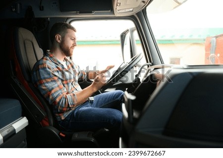 The truck driver looks at the documents for the cargo he is transporting Royalty-Free Stock Photo #2399672667