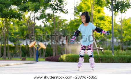 Asian kid girl practicing roller skating. Children wear elbow guard and knee guard to prevent severe injuries caused by impacts when playing challenging sports. Child 6 years old.