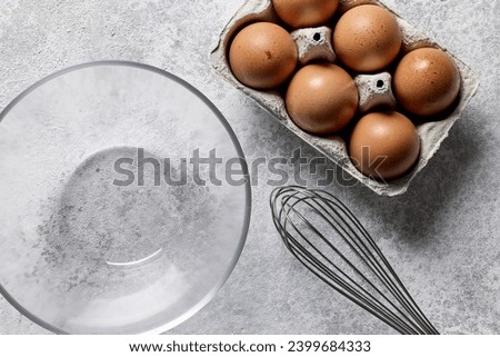 bowl and eggs on light grey painted kitchen table background, top view