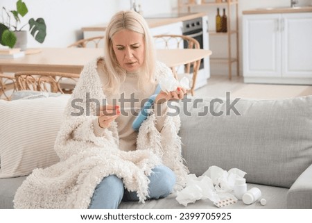 Ill mature woman with thermometer at home