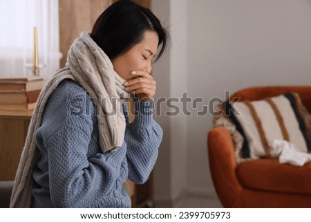 Ill Asian woman coughing at home