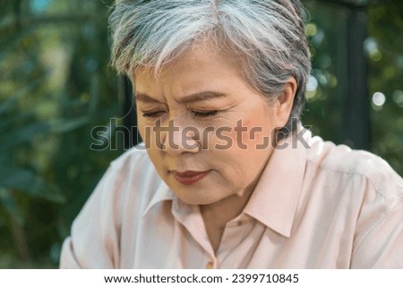 Asian elderly 60s female with gray hair has problem eye ache farsighted pain, senior pensioner retirement woman heahache or stressful after reading book too long, health care old aging concept 