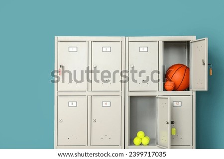 Modern locker with sports equipment near blue wall Royalty-Free Stock Photo #2399717035