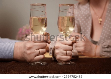 Hands Man and woman sitting at table with glasses of champagne. Hands with rings on the fingers. Newlyweds and divorce. Quarrel, swearing, hatred, holiday, wedding, newlyweds